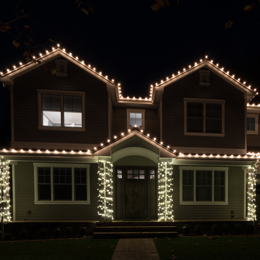 Image of a neighbourhood from above glowing with holiday lights 